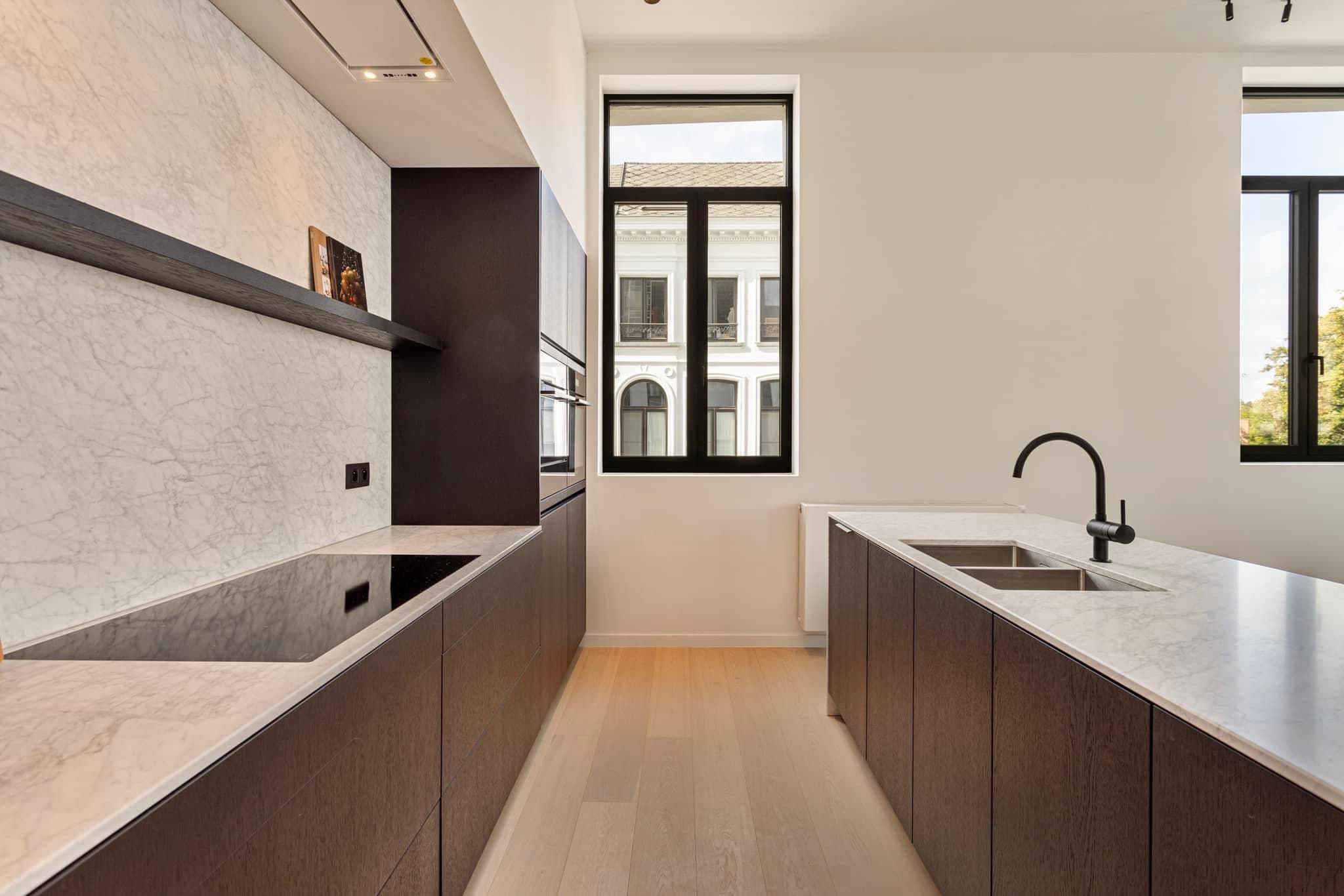 Lichte en moderne keuken in Lier, afgewerkt met strakke zwarte Ferro 99 ramen die het daglicht binnenlaten