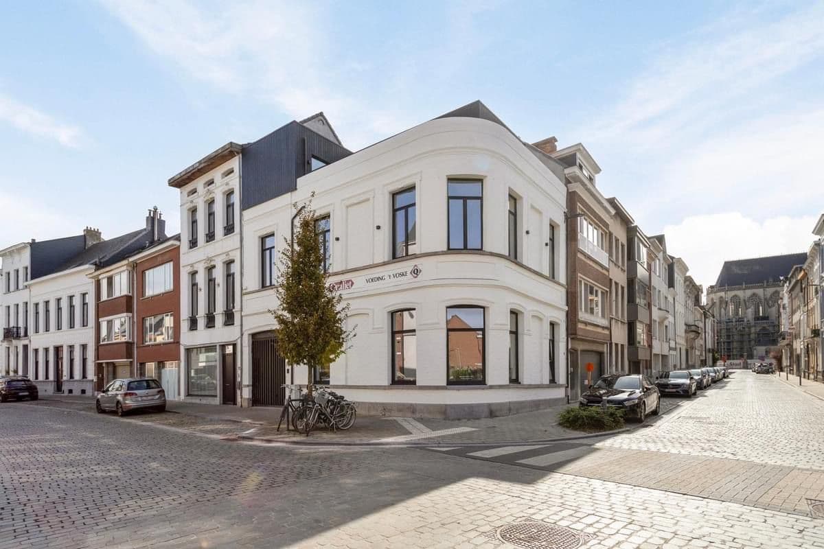 Zicht op de voorgevel en zijgevel van het prachtig gerenoveerde hoekpand in Lier met zwarte Ferro 99 aluminium ramen